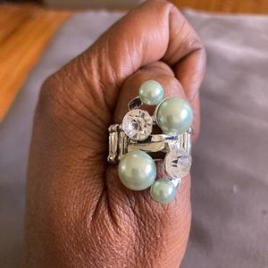 Green, silver and diamond type ring. One size fits most with a stretch band.